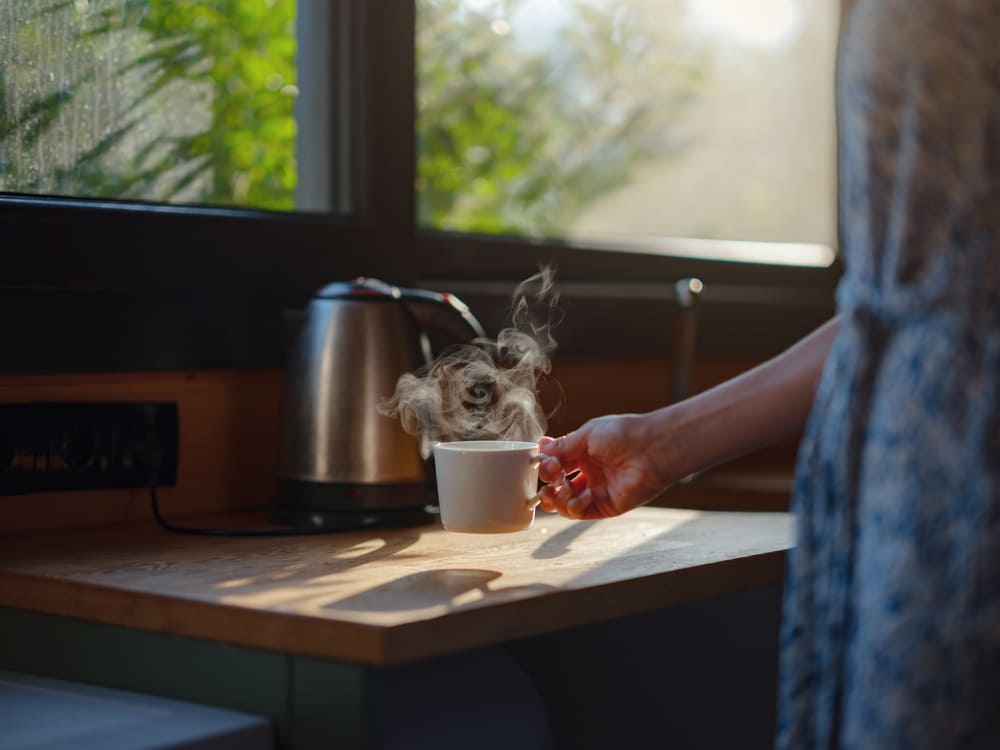 Kobieta przygotowująca sobie rano kawę. 